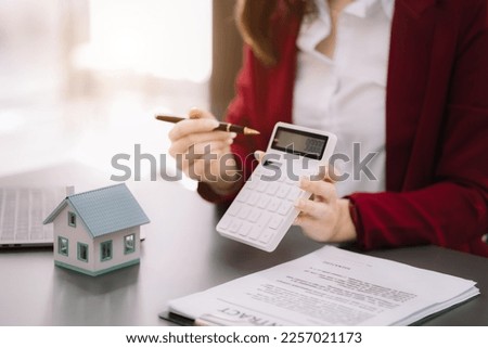 Buying a home or insurance deal, an insurance agent pointing a pen to those interested in renting a house, a contract, signing an Home buying agreement in office.
