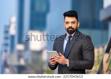 Portrait of a handsome young businessman using a digital tablet