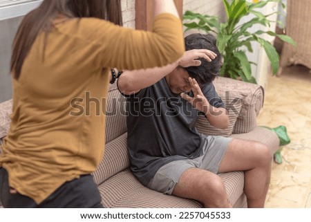 A battered husband defends himself from being hit by his abusive and violent wife. Physical abuse, domestic violence and toxic relationship. Royalty-Free Stock Photo #2257045533
