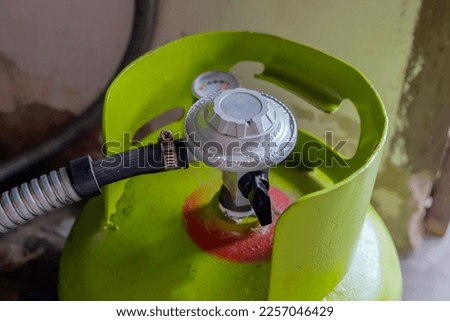 Green LPG gas cylinder with regulator installed Royalty-Free Stock Photo #2257046429