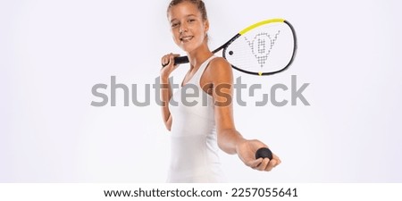 Squash player with a racket. Beautiful girl teenager athlete on white background. Sport concept. Download a photo for an sports advertising.