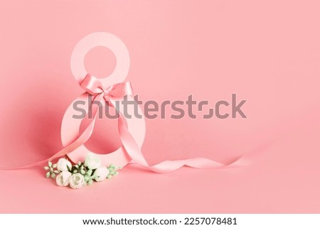 Paper cut eight with ribbon on pink background. Postcard March 8 on a pink background Royalty-Free Stock Photo #2257078481