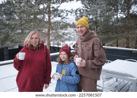 Happy family portrait of dad, pregnant mom and daughter. Outdoor photo. 