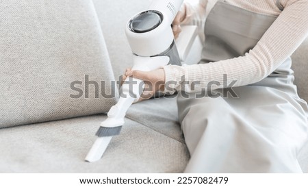 Beautiful woman vacuuming the sofa and pillow of her living room, Big cleaning in the house, Removes germs and dirt and deep stains, Housewife cleaning, Keeping her home clean, Domestic hygiene. Royalty-Free Stock Photo #2257082479