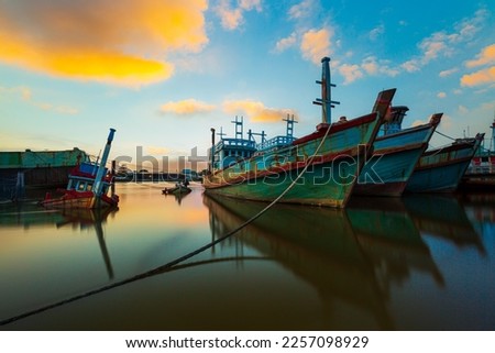 Fishing boats and evening sky,Picture of a fishing boat facing a high oil crisis at sunrise, Thailand