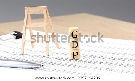 wooden cubes with the word GDP stand on financial background, business concept.