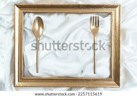 Restaurant poster, menu, business card luxury mockup. Creative concept of a dinner setting with golden frame, spoon and fork