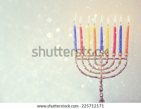 Image of jewish holiday Hanukkah background with menorah Burning candles over aqua glitter overlay