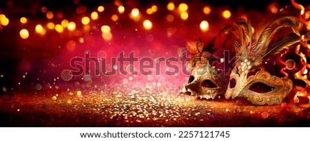 Carnival Party - Venetian Masks On Red Glitter With Shiny Streamers On Abstract Defocused Bokeh Lights Royalty-Free Stock Photo #2257121745