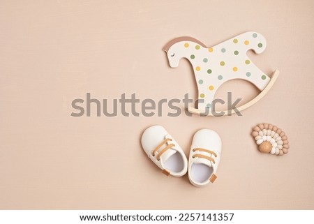 Gender neutral baby shoes, rocking horse and teether. Organic newborn fashion, branding, small business idea Royalty-Free Stock Photo #2257141357