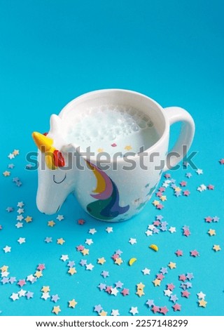 Moon milk - blue drink in unicorn cup on the blue background