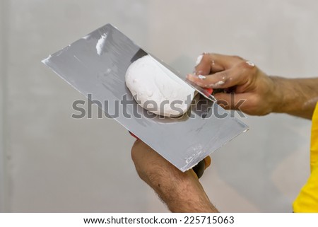 trowel full of plaster, skim coating a wall Royalty-Free Stock Photo #225715063