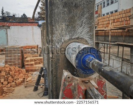 Hole cutting machine. Drilling concrete with an industrial drilling machine with an industrial diamond grain. Core drills used in ring cutters for reinforced concrete columns Royalty-Free Stock Photo #2257156571