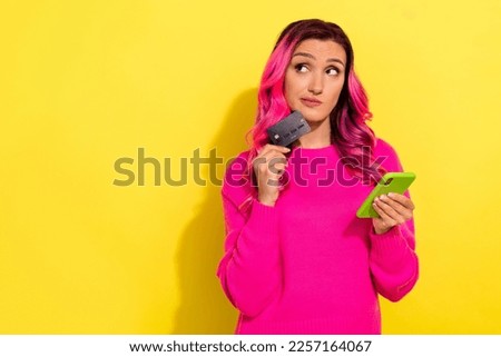 Photo of thoughtful youth lady use gadget debit card buy online website pay virtual isolated on yellow color background