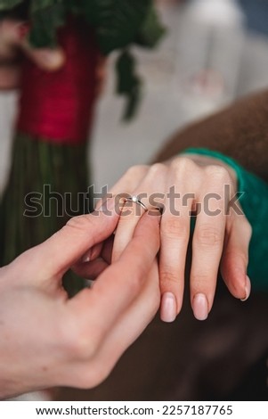 Man proposed to marriage. Picture a man putting an engagement ring on a woman's hand, outdoors.