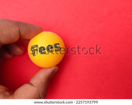 Hand holding ping pong ball with the word Fees