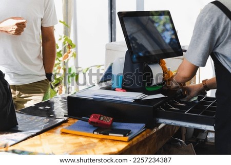 Woman cashier at counter service changing money for customer. Royalty-Free Stock Photo #2257234387