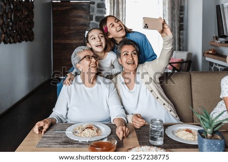 hispanic Multi Generation women Family Posing For photo Selfie at dinner time At Home Together in Latin America Royalty-Free Stock Photo #2257238775