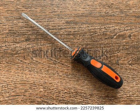 A flat head screwdriver on a wood background Royalty-Free Stock Photo #2257239825