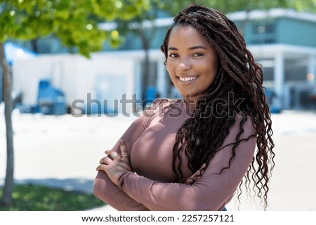 Pretty african american woman with braid outdoor in summer in city Royalty-Free Stock Photo #2257257121