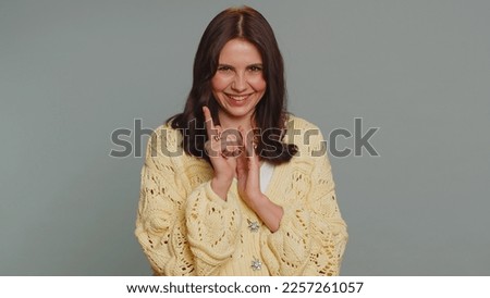 Sneaky cunning pretty woman with tricky face gesticulating and scheming evil plan, thinking over devious villain idea, cheats, revenge, jokes, pranks. Young girl isolated on gray studio background Royalty-Free Stock Photo #2257261057