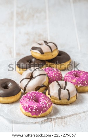 Colorful Donuts, Berliner, Krapfen with sugar icing and chocolate on white wooden background, vertical with copy space Royalty-Free Stock Photo #2257279867