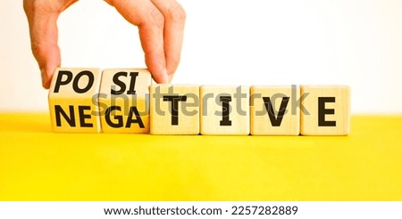 Positive or negative symbol. Businessman turns wooden cubes and changes the word 'negative' to 'positive'. Beautiful yellow table, white background. Business, positive or negative concept. Copy space.