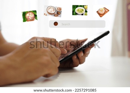 young man sitting on a smartphone in the room Choose a menu of Thai desserts. (spot focus)