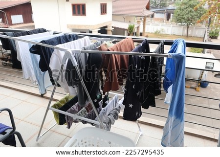 Laundry hanging on drying rack at apartment balcony. Royalty-Free Stock Photo #2257295435