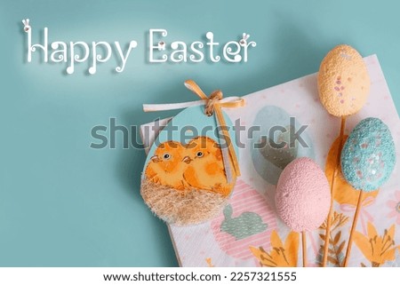 Easter decor, decoration for Easter - napkins for food and artificial eggs in pink, yellow and blue on a blue background