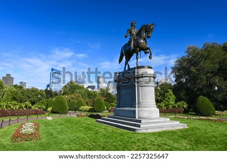 The statue of General George Washington at the entrance to the public gardens of Boston, Massachusetts. The skyline of the city is in the background.