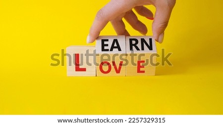 Learn and Love symbol. Businessman hand turns wooden cubes and changes word Love to Learn. Beautiful yellow background. Lifestyle and Learn and Love concept. Copy space.