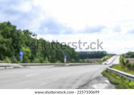 Blurred view of countryside road with green trees
