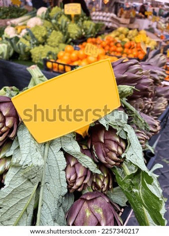 supermarket, blank or empty price tag on fresh artichokes with selective focus in open farmers market. fresh ripe artichoke on vegetable stands or displays in greengrocery with label with copy space