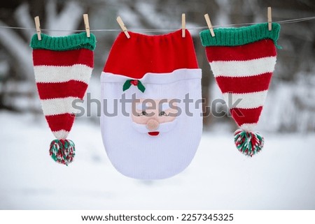 Santa's Christmas bag and striped hats are dried on a rope. Preparing to celebrate Christmas.