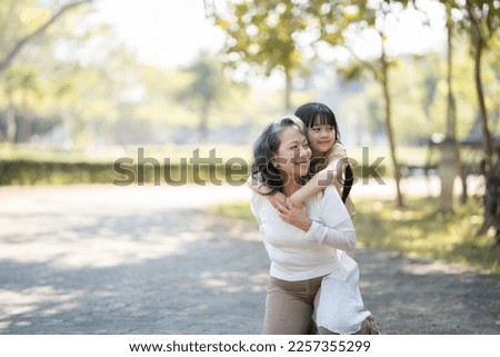grandmother and granddaughter hugging in the park   Royalty-Free Stock Photo #2257355299