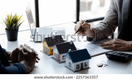 Real estate agents explain models of housing estates in projects to elaborate to clients, explaining and presenting information about homes and purchasing loans. Real estate trading concept.