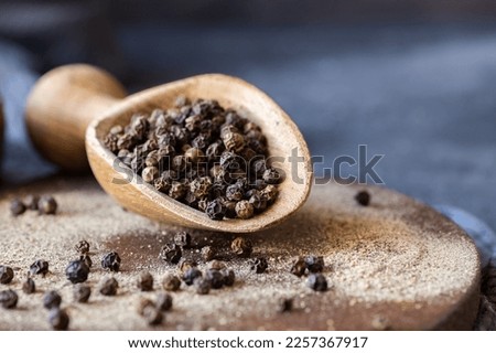 Heap of black pepper, peppercorns in spoon with milled powder on rustic background, dried spice peppercorn concept Royalty-Free Stock Photo #2257367917