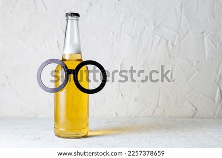 A bottle of beer with a symbolic glasses on white background. Concept of a party, father's day, bachelor party, february 23