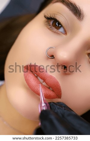 Close-up model's lips performed with permanent lip makeup. Lip tattoo work after tattoo Royalty-Free Stock Photo #2257385733