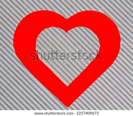 Corrugated paper cut into heart shapes of various sizes on a red background