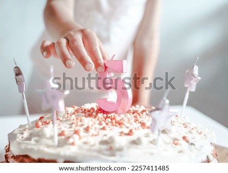 Big pink 5 number candle on homemade cake. Creative congratulations on five years for child girl. Festive decoration for 5th birthday, topping, dressing. Merry home holiday, party with mom, family.