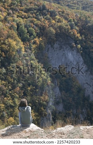 lonely person sits and looks at the nature of the beautiful forest of the mountain