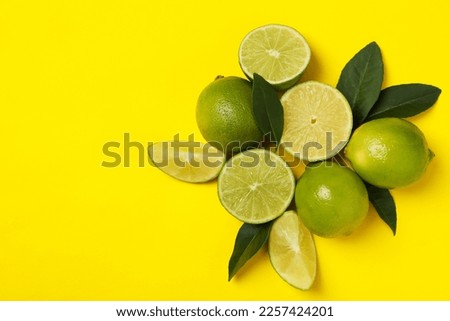 Ripe lime on yellow background, space for text