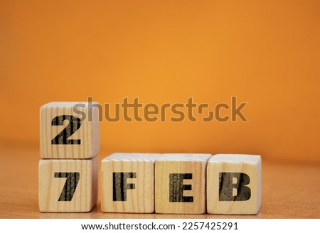 Cube shape calendar for february 27 on wooden surface with empty space for text, new year Wooden calendar with date, February cube calendar on wooden surface with copy space.