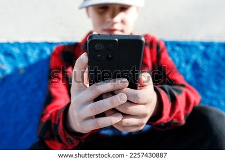 Close-up of a teenager's hands holding a phone for communication
