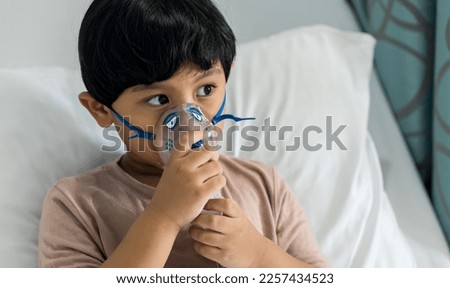 Sick boy inhalation therapy by the mask of inhaler. Baby has asthma and need nebulizations. Patient Boy use inhalation with Nebulizer mask at hospital. The baby are spraying bronchodilators . Royalty-Free Stock Photo #2257434523