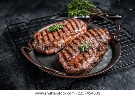 Grilled Top Blade or flat iron beef meat steaks. Black background. Top View. Royalty-Free Stock Photo #2257454831