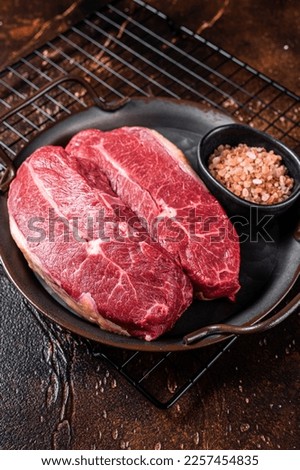 Raw wagyu oyster top blade steaks, organic beef meat. Dark background. Top View.