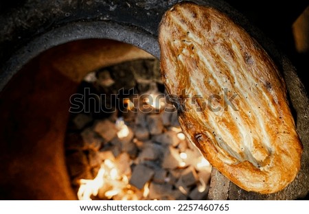 Cooking tandir bread (traditional Azeri bread) in a naan fire oven. Traditional food of Azerbaijan. Royalty-Free Stock Photo #2257460765
